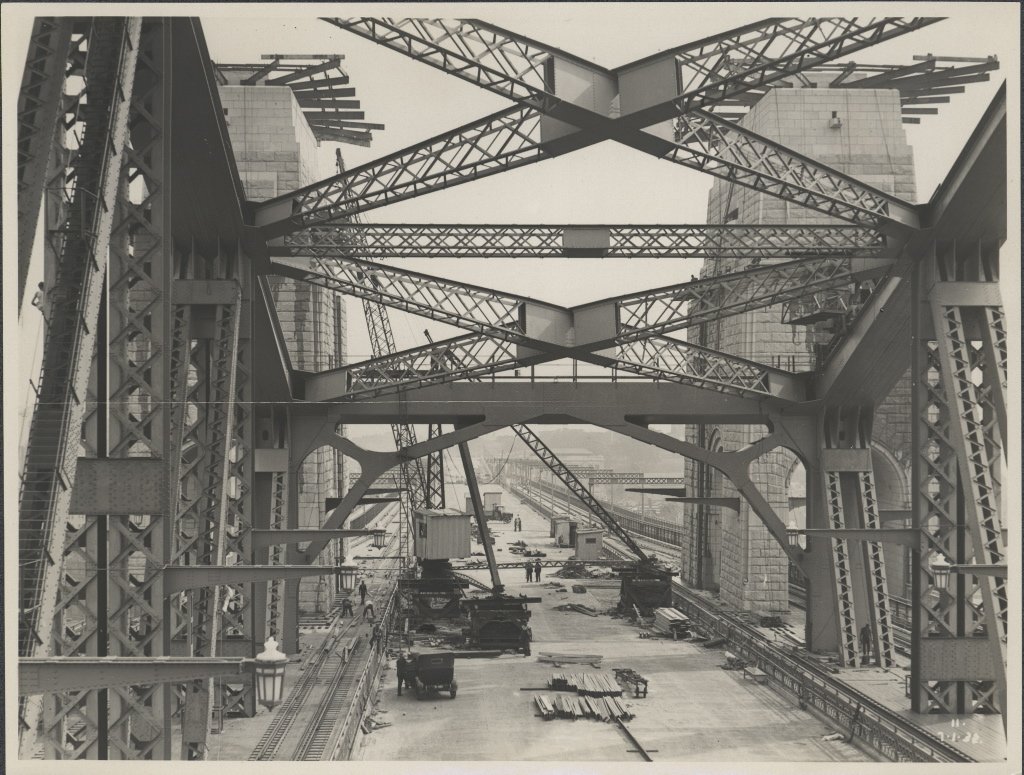 Cranes and workmen on the central roadway of the Sydney Harbour Bridge, 1932