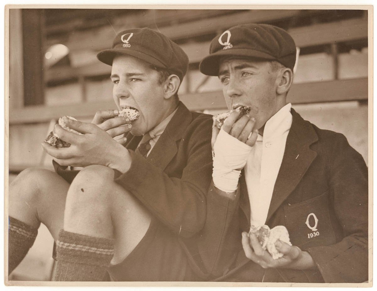 Schoolboy fans eat cake, c. 1930, by Sam Hood, Moore Park