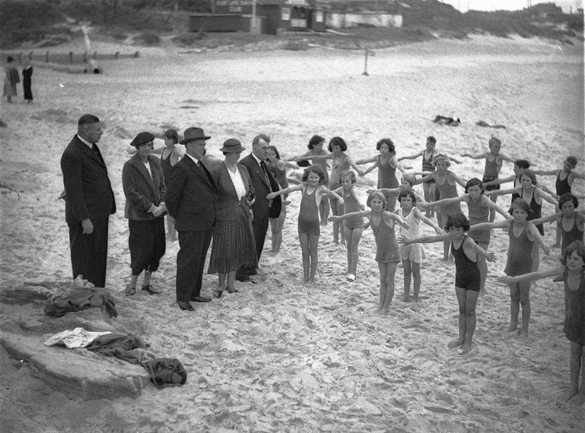 Inspectors of Schools and Swimming watch Stewart House swimming exercises on the beach, South Curl Curl, 10 Jan 1935, by Sam Hood
