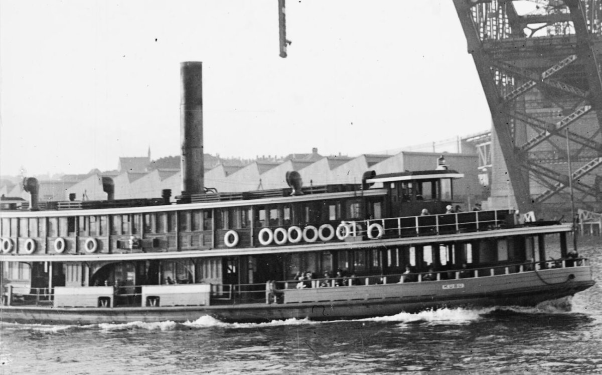 Sydney ferry KUBU under the Sydney Harbour Bridge under construction circa 1930 (c. 1930)