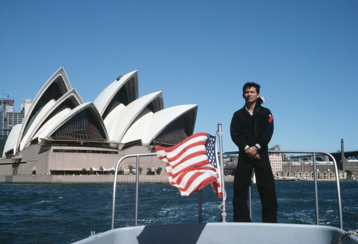 Engineman Fireman (ENFN) Glenn Altares, a small boat engineer, stands at his duty station as the utility boat motors past the Sydney Opera House during the Australian bicentennial c - DPLA - 0ca53e10dda3d09c702f53a2e6041bca, Sydney city centre (1988)