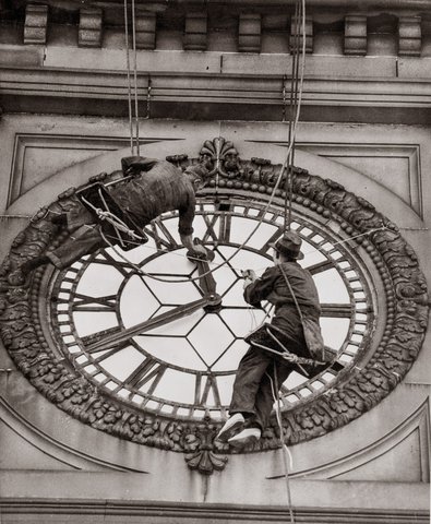Cleaning the clock face of Sydney Town Hall, George Street Sydney, 1937