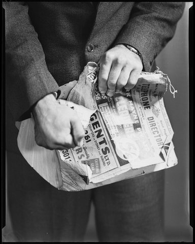 Man tearing telephone directory, 1938
