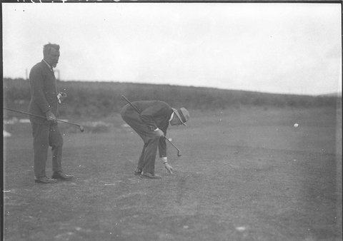 A golfer replacing the divot, 1930s