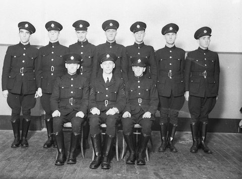 A group of nine RAAF Citizen Air Force ground staff with their Sergeant in preWW II uniform tunics buttoned to the neck peakedcap navy blue breeches and black leggings, c. 1932