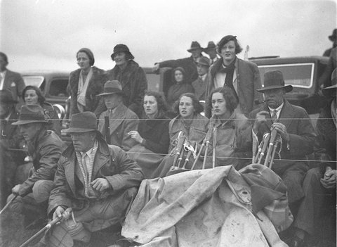 A group of spectators suffer the cold weather, 1930s
