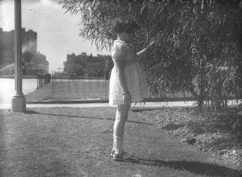 A little girl admires the Spring blooms, 1934
