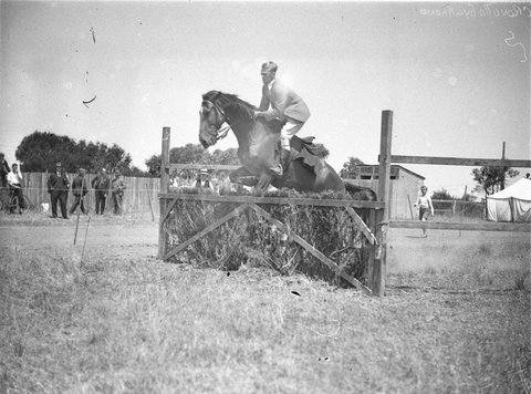A male rider clears the brush hurdle, 1920–30