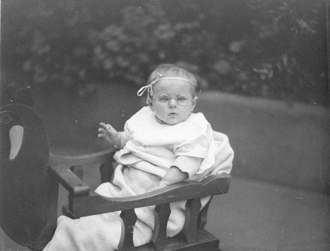 A small baby wearing spectacles, 1930s