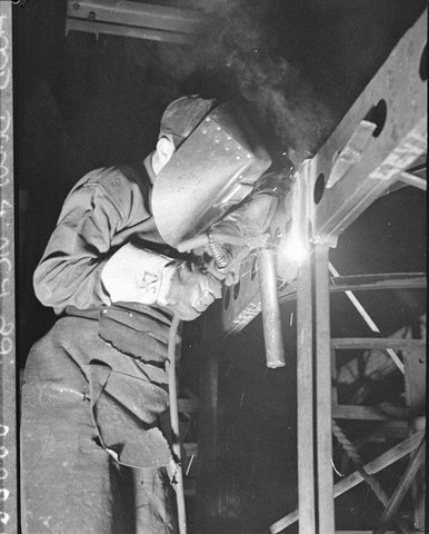 A welder at work building doubledecker bus bodies, 1937