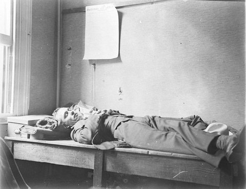 An injured worker lies waiting for an ambulance, 1930s