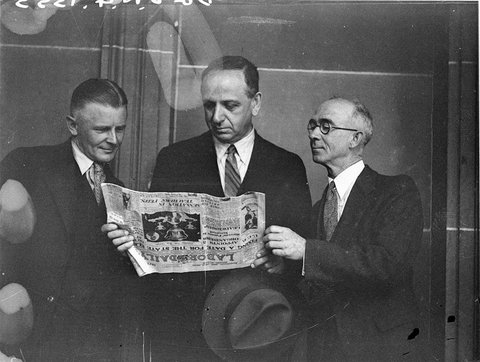 At the Teachers Conference three men discuss the frontpage story in the Labor Daily 17 December 1934 on the defeat of the president Dr C H Currey and other officials of the Country Committee executive