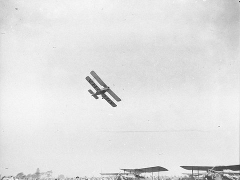 Avro Avian VHUIV doing aerobatics over the top of other aircraft on the ground, c. 1934
