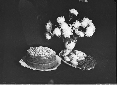 Cakes and vase of flowers taken for Smiths Weekly cookery page, 1947
