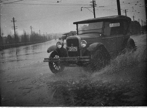 Car on flooded street, 1930s