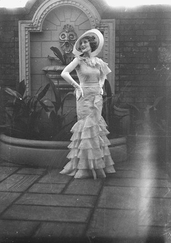 Fashion model posing near fountain, 1934