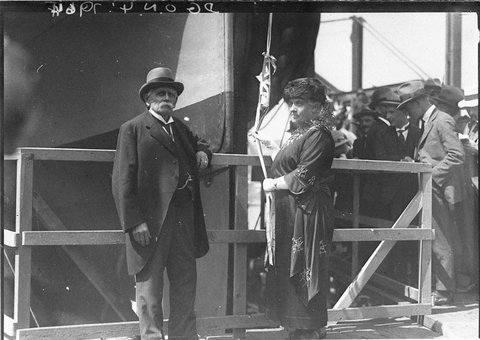 Frockcoated VIP and his lady about to christen a ship, 1930s