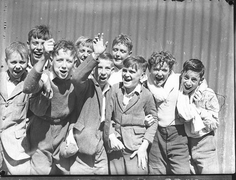 Group of schoolboys cheering at swimming caarnival, 1935