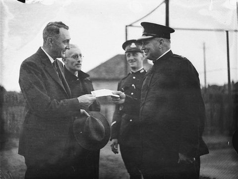 Inspector Dole presents RS Andrews Director of Hornsby Hospital with a cheque for 164 pounds proceeds of a Police ball Chatswood Police Station, 1934
