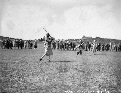 Large gallery watching unidentified woman driving down the fairway, 1930s
