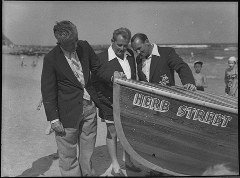 Launching Cooks Hill surf boat Deputy State Superintendent of Surf Lifesaving Association Mr R Bryden President of branch Mr A Reynolds and President of Cooks Hill club examine new boat, 1953