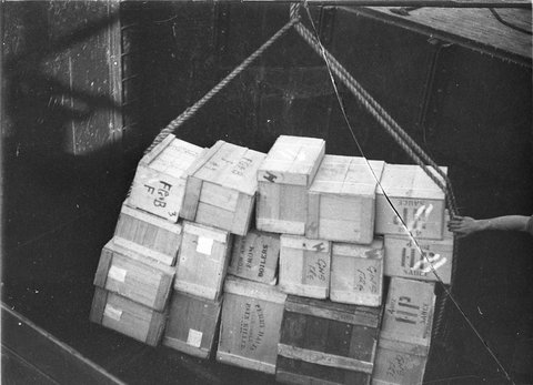 Loading wooden boxes into the hold of a ship, c. 1930
