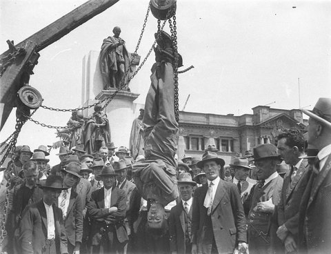Murray the Escapologist is hauled up by his feet in a straightjacket in Shakespeare Place Sydney 16 Feb 1928
