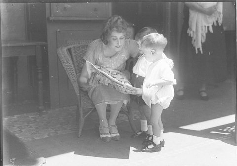 Musical comedy star Dorothy Brunton reading The Sun comics with two small boys, 1925