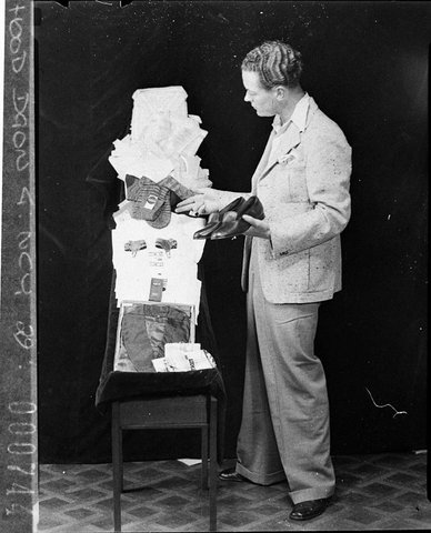 Mutual Group System copy for Mr Lamb A man examining the clothes, 1938