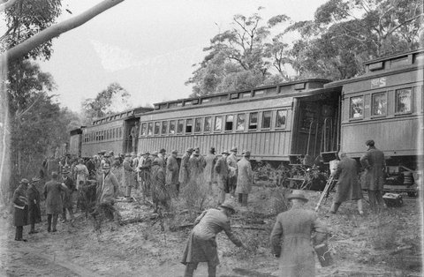 Pressmen riding on tender of small gauge loco on way to inspect shale oil refinery, 1932