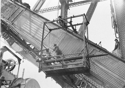Riggers riveting the redhot rivets on the lower outside south chord, 1930–32