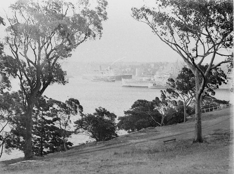 Scene from Domain as ocean liner passes a ferry and HMAS Australia, 1930s