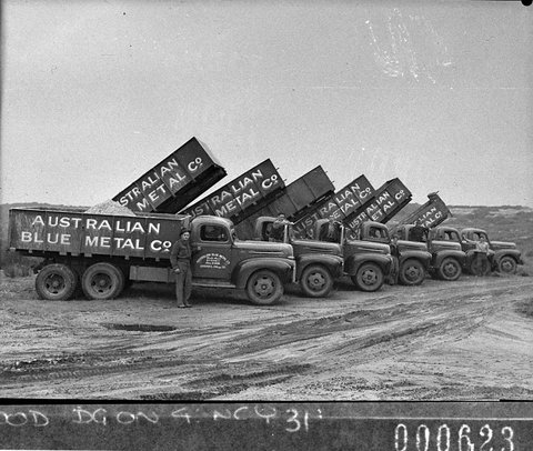 Seven trucks lined up with six tipping Australian Blue Metal Co trucks for Mr Freeman Ford News, 1944