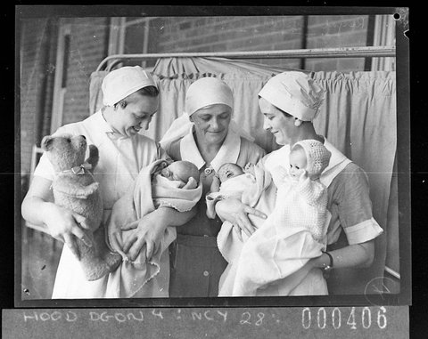 Sister between two nurses holding babies, c. 1936