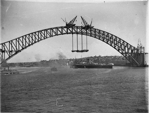 The first panels of decking in place as ocean liner passes underneath, 1931–32