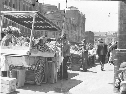 Three fruit barrows selling on a city street, c. 1933
