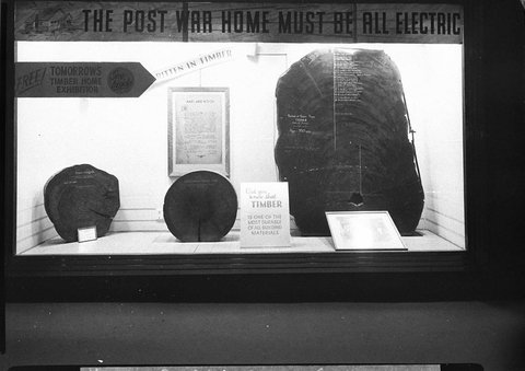 Timber Homes Exhibition notice reads The post war home must be all electric in a city shop window, 1944