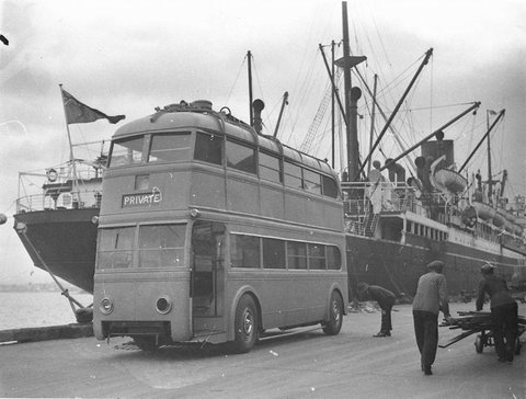 Trolley bus being unloaded from ship from England, 1934