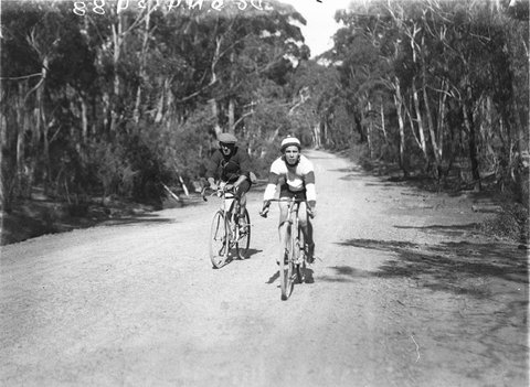 Two cyclists on a bush track, 1930s
