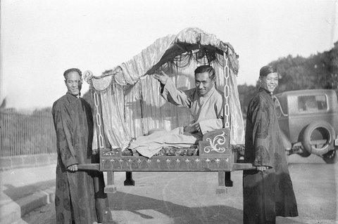 Two unidentified Chinese dignitaries being carried in sedanchairs by other Chinese, 1930s
