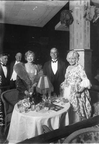 Two women and a man in evening dress at the Movie Ball Palais Royal, c. 1929