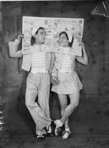 Unidentified clown tap dancers act couple with their heads through the Sun front page, 1930s