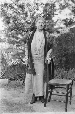 Unidentified woman dowager with shawl background of wattle, 1930s