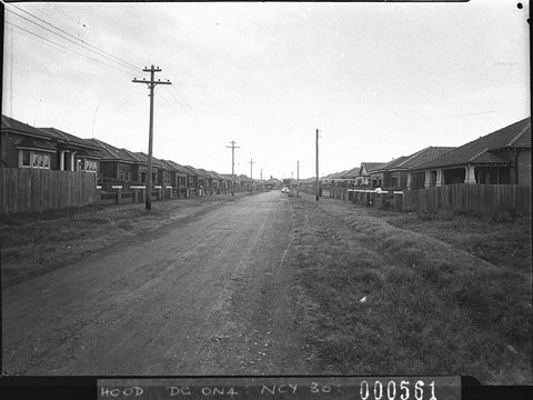 Unmade suburban street with houses on each side taken for Mascot Council, 1938