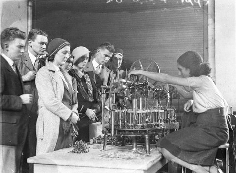 Visitors watch girl operating filament winding machine, c. 1931