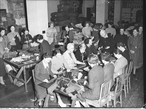 Women volunteer workers doing up clothing parcels at the ACF rooms taken for Australian Comforts Fund, 1944