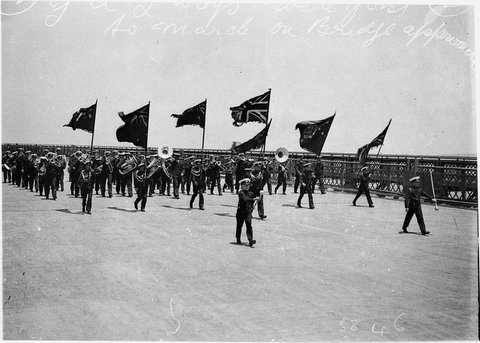 Young Australia League YAL Bandsmen play as the last section of the deck on north side is being set in place, 1931