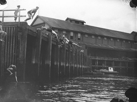 Young men diving into the Harbour at central wharf Millers Point, 1935