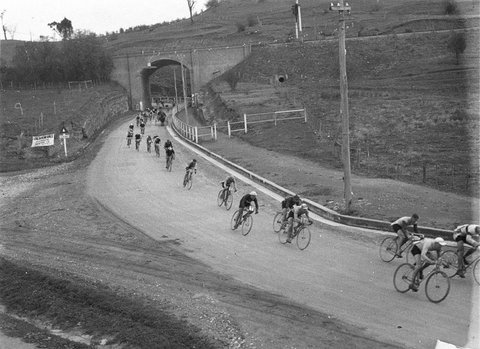 A line of cyclists coming through the arch of the railway bridge at Picton, 1934