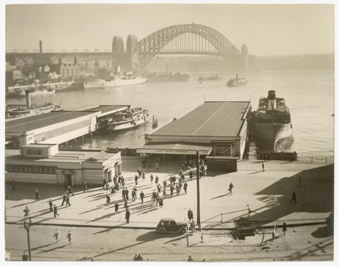 Morning passengers leave the Manly ferry with wharves and Harbour Bridge in the background, Circular Quay, ca. 1946-1949 by Australian Geographical Society, 1946–49